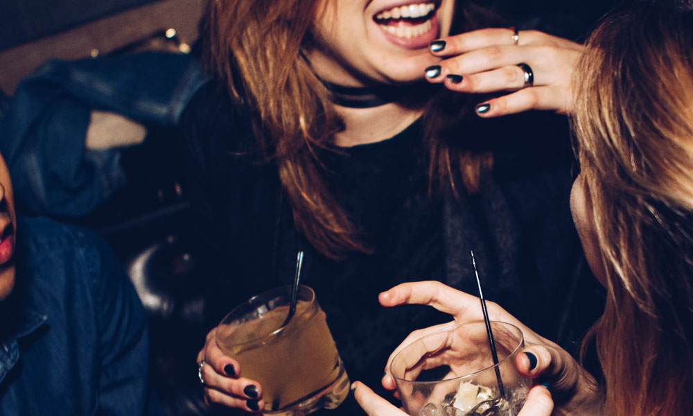 Women drinking and laughing at a bar